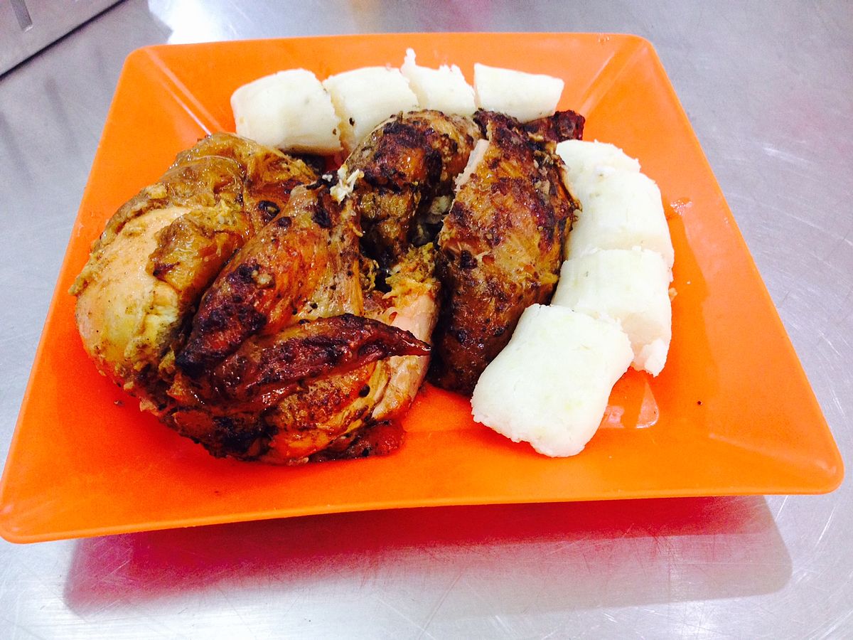 The dish is served on an orange plate, with rice balls surrounding it.