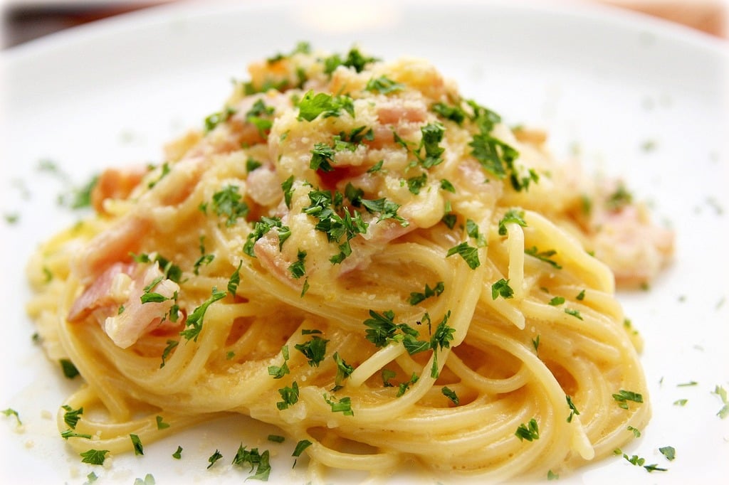The creamy, pasta dish is cooked with bacon.